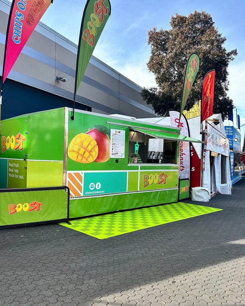 A green Boost Juice trailer at the Royal Adelaide Show with an ULTRAGRID Electric Green floor mat in front of the serving window