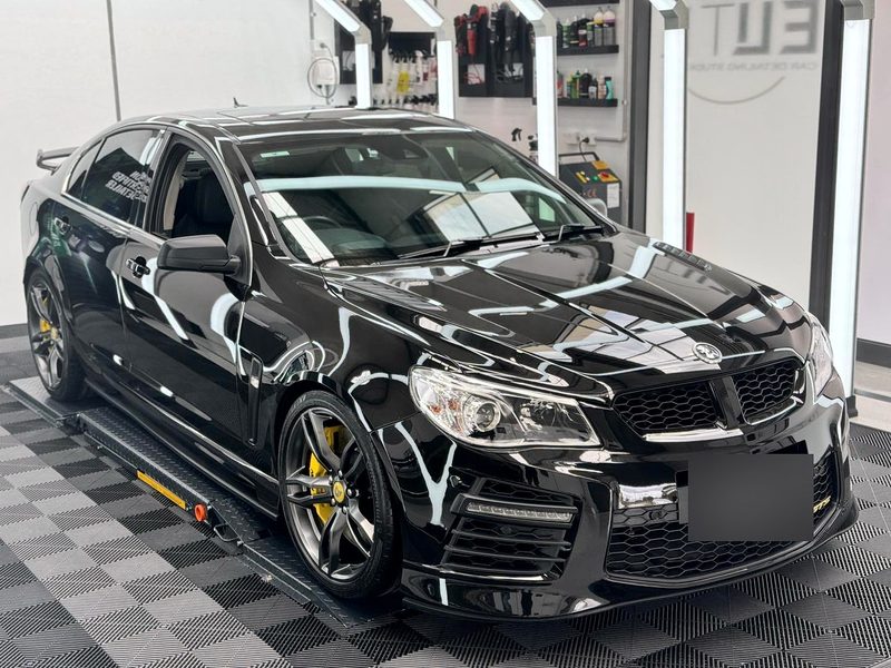 Three-quarter view of a black car on an ULTRAGRID floor in Jet Black and Space Grey at Elite Car Detailing Studio