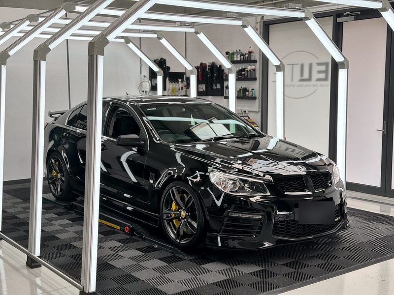 Black car under the light tunnel on an ULTRAGRID chequer in Jet Black and Space Grey