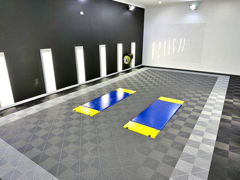 DPG Detailing studio in Mount Gambier with a dark feature wall, tall wall lights and an ULTRAGRID floor in Jet Black, Silver Grey and Space Grey with a lighter border band