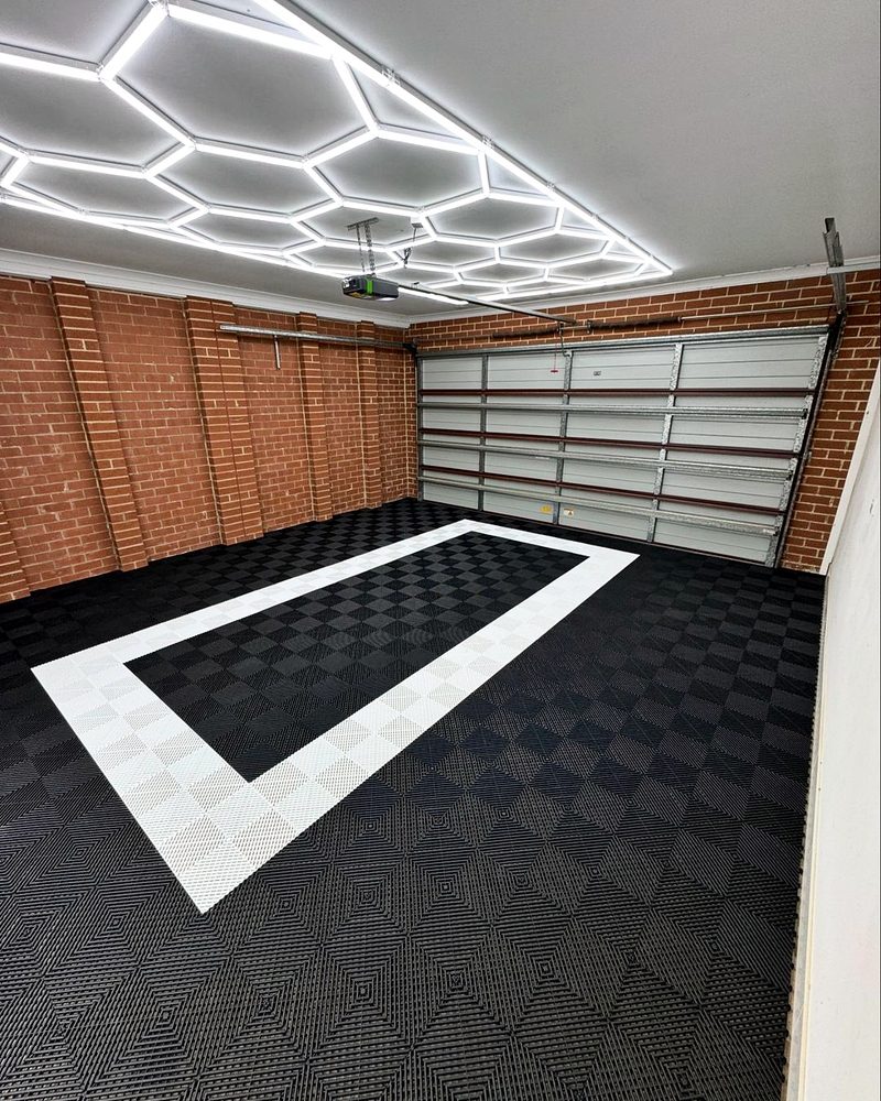 The Alpine White corner of the outline on the Jet Black ULTRAGRID floor, brick wall behind