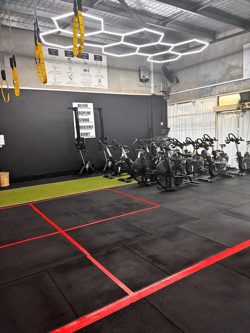 ULTRABEAM hexagon LED lights above a row of exercise bikes and the front windows at Tailored Fitness