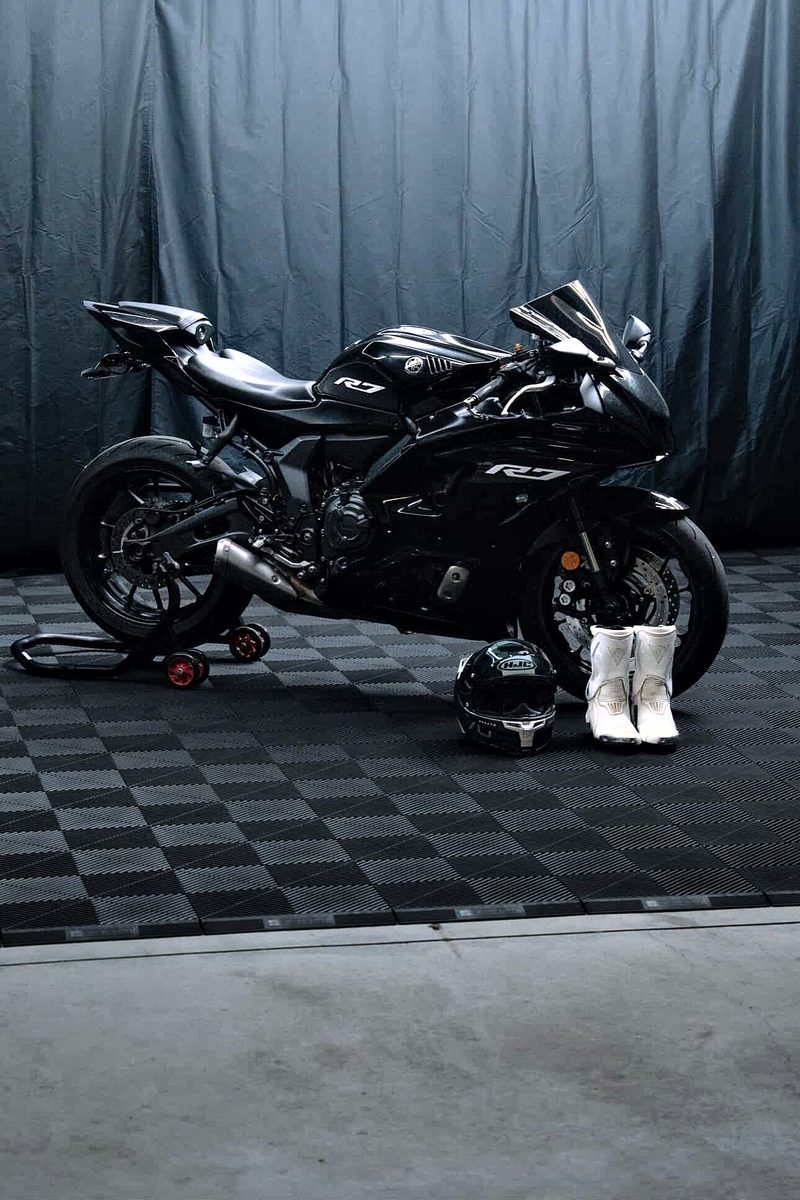 The sportbike with a helmet and white boots on the Jet Black ULTRAGRID floor