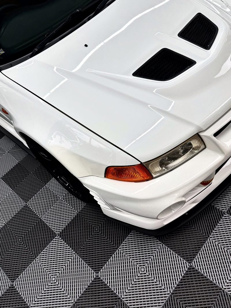 Close on the bonnet of the white Evolution with the ULTRAGRID Silver Grey and Space Grey tiles below