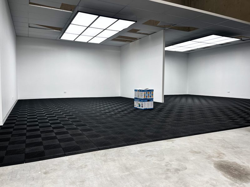Wide view of the F90 Auto Detailing unit with the Jet Black ULTRAGRID floor across two rooms