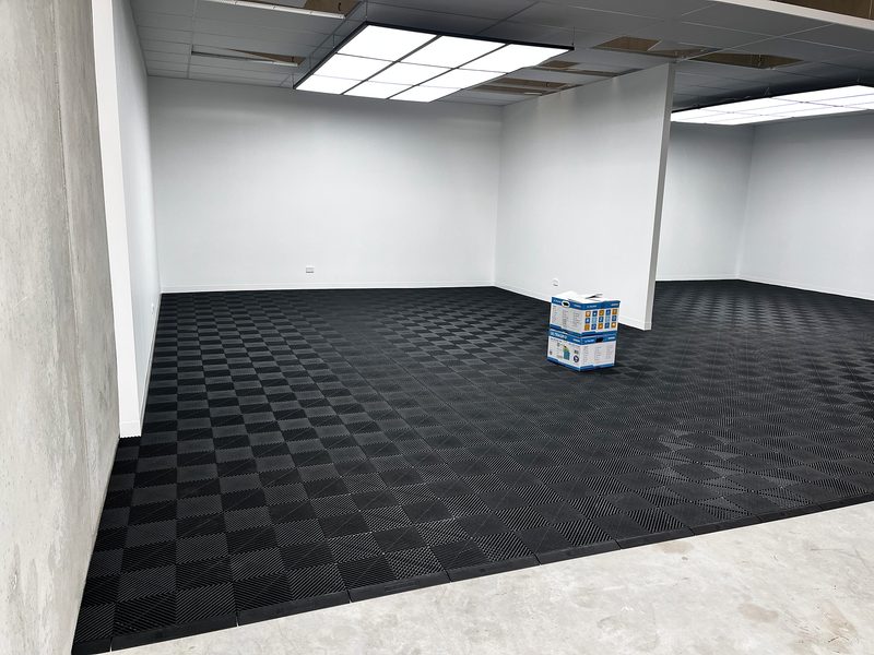 Second wide view of the Jet Black ULTRAGRID floor with its Jet Black ULTRAEDGE ramp edge at the bare slab