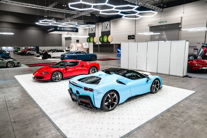 Ferrari 296 GTB and Ferrari SF90 on a white ULTRACORE Alpine White pad with ULTRABEAM hexagon lights above