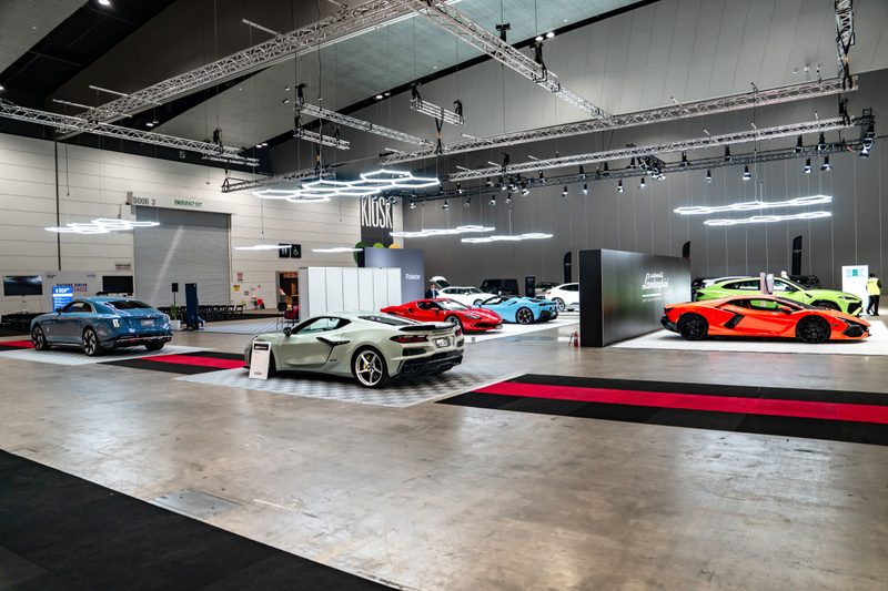 Wide view of the hall at the Melbourne EV Show with car pads under ULTRABEAM hexagon lights