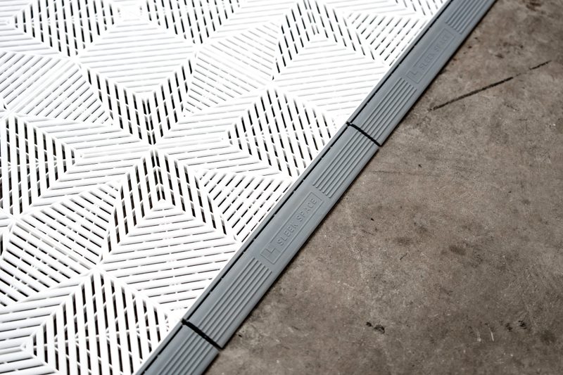 Corner of the ULTRAFLUX Alpine White pad with an ULTRAEDGE ramp edge on the hall floor